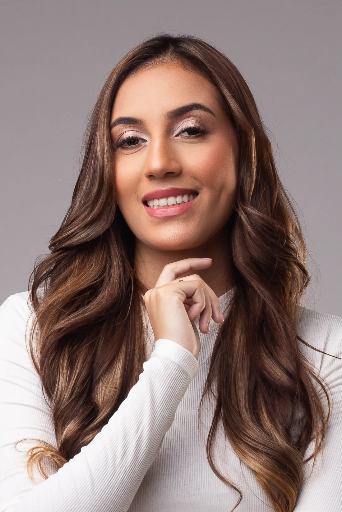 Retrato de Nicoly Beatriz sorrindo, com a mão no queixo